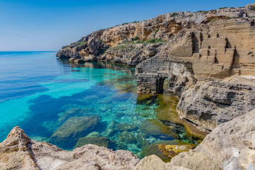 Cave di tufo bianco a Bue Marino, Favignana, viste dal mare durante l'escursione in gommone